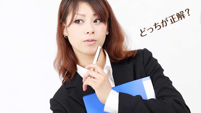 ペンを顎先に当てながら悩む女性事務員