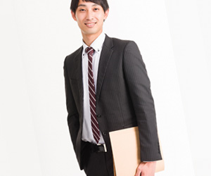 書類をもつスーツ姿の男性