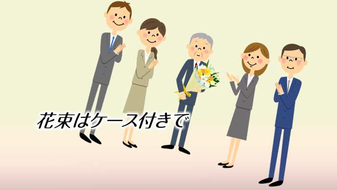 花束を持って同僚に囲まれる退職者