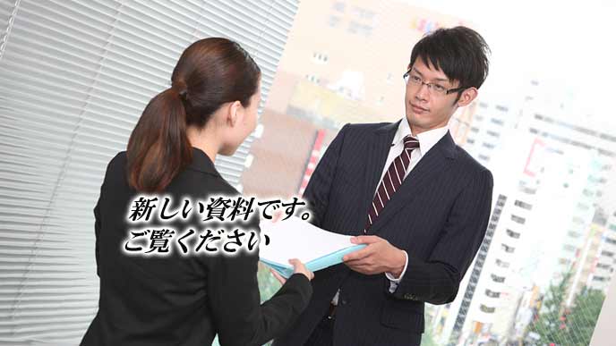 資料を手わたす女性社員