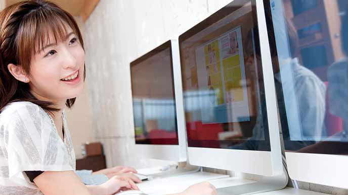 モニター画面を見ながらグラフィック制作をする女性