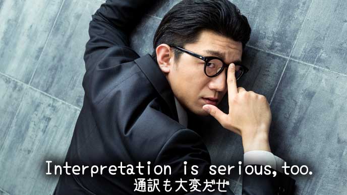 眼鏡をかけて壁に寄り掛かる男