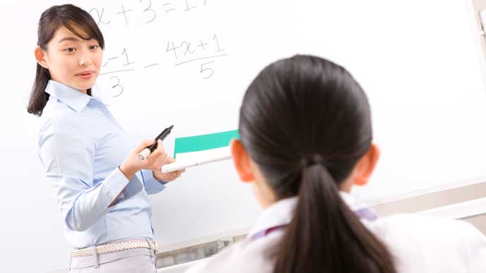生徒に勉強を教える塾講師