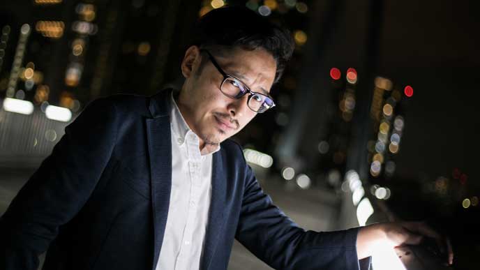 夜の屋上で悩む男