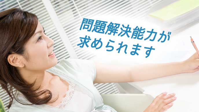 シャープペンシルを持って事務仕事をする大学事務員