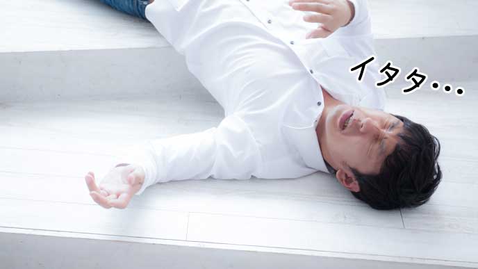 階段で転び怪我をする男
