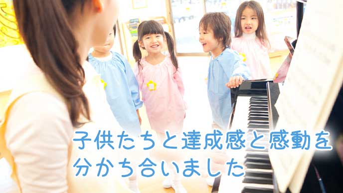 ピアノを弾いて子供達と一緒に歌う幼稚園教諭