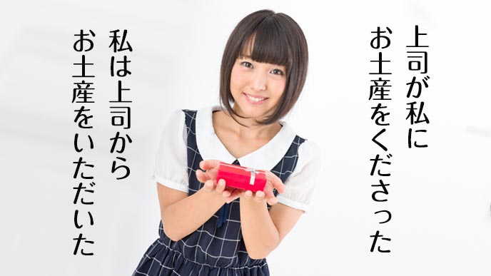 お土産を手のひらに載せて微笑む女性