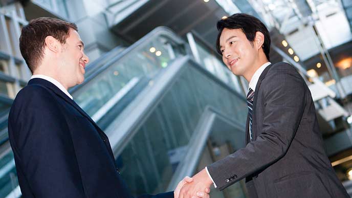 外人社員と日本人が握手する