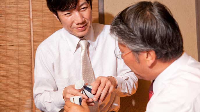 会社の飲み会で上司にお酌をする幹事