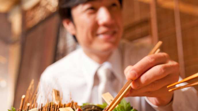 宴会の席で料理を食べるビジネスマン