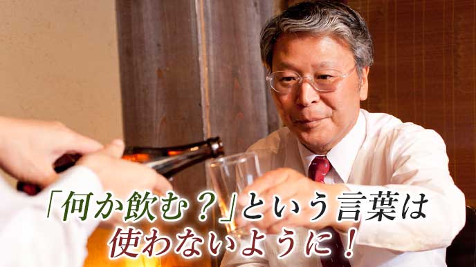 会社の宴会でビールを部下に注いでもらっている上司