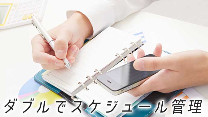 スマートホンのアプリと手帳でスケジュールを管理しているビジネスマン