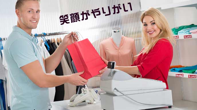 レジで客に商品を手渡す店員