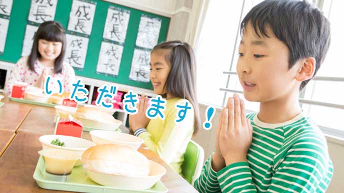 管理栄養士が作った給食に「いただきます！」と手を合わせる小学生