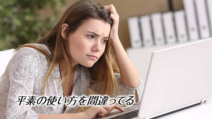 会社のデスクでメールを読みながら困惑する女性