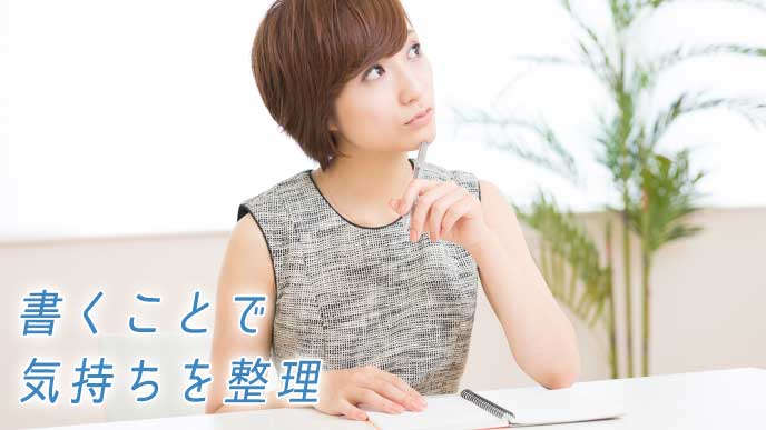 手帳を開き考え事をする女性