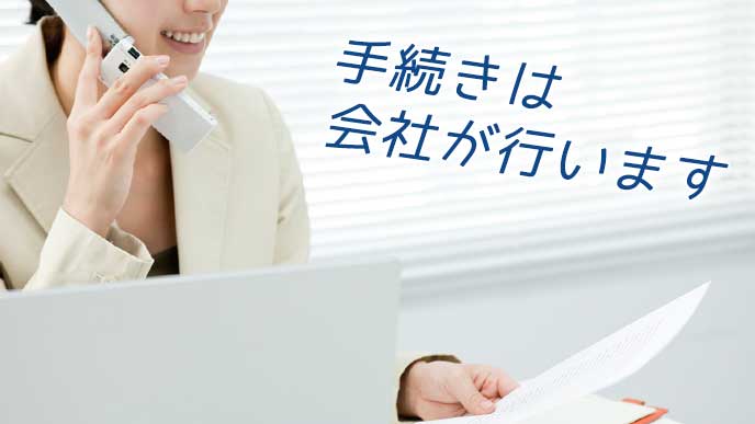 書類を見ながら電話で手続きをする会社員の女性