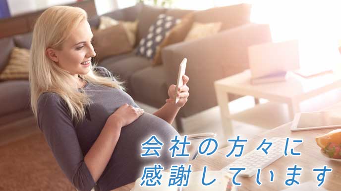 自宅で椅子に座りスマホを見る妊婦