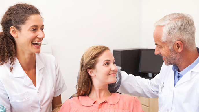 患者の虫歯が治って喜んでいる歯科医と歯科助手