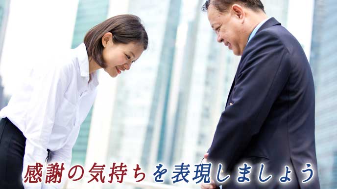 お世話になった上司に礼をする会社員の女性