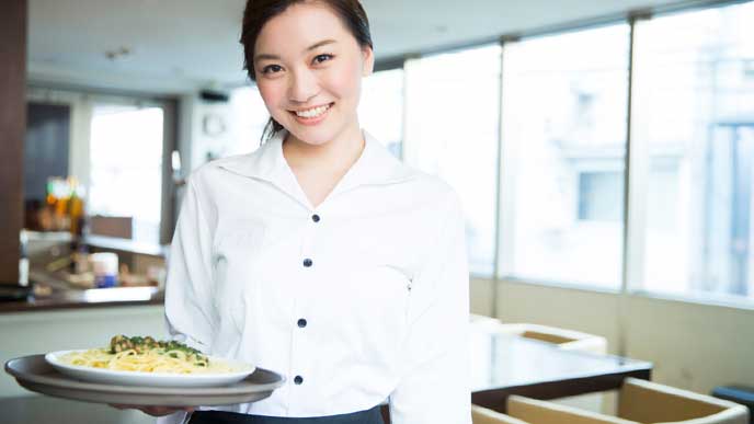 パスタを運ぶレストランのオープニングスタッフ