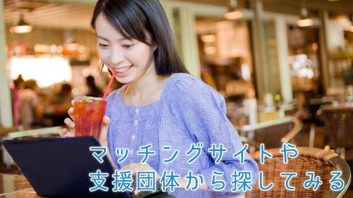 カフェでアイスティーを飲みながらインターネットをする女性