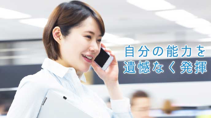 スマホで仕事の電話をする会社員の女性