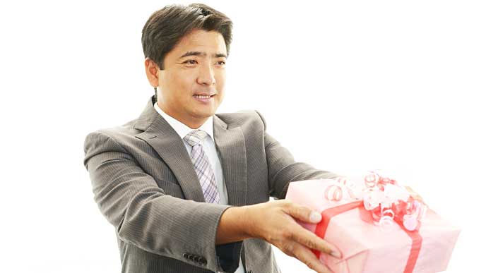 手土産が入った箱を渡すビジネスマン