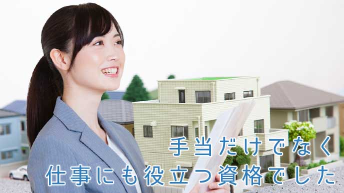 不動産の仕事をする女性と住宅地のミニチュア