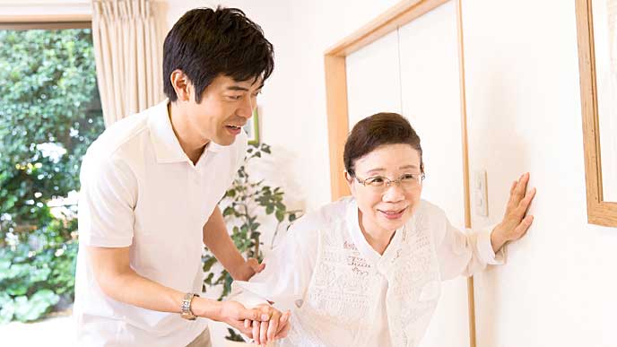 お婆さんの歩行介助をする介護士の男性