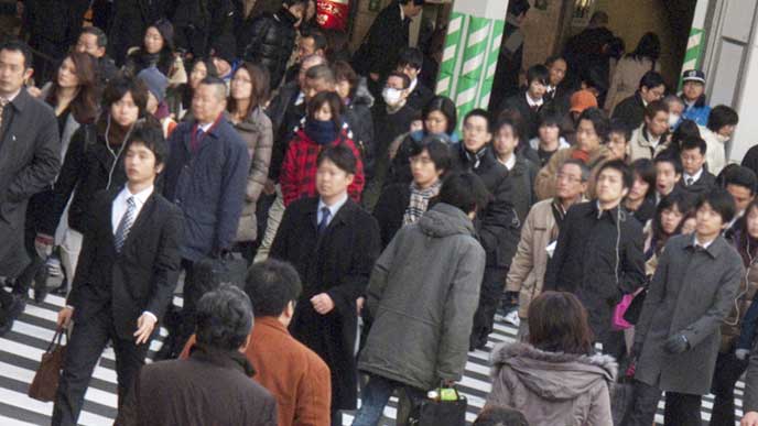 横断歩道を歩く通勤中のサラリーマン達