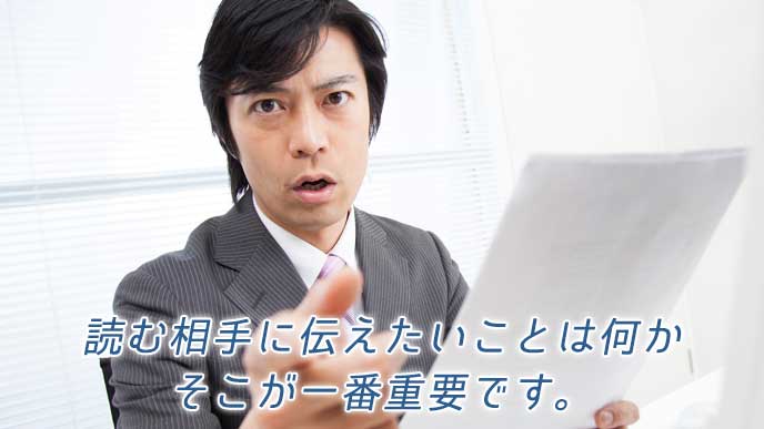 報告書を片手に持ち正面を指さすビジネスマン