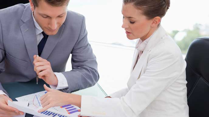 上司に提出した報告書の内容を説明する会社員の女性