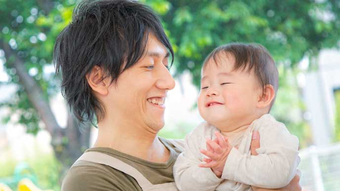 笑顔で赤ちゃんの育児をする男性
