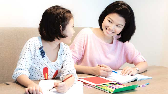 子供とお絵かきをしているベビーシッター