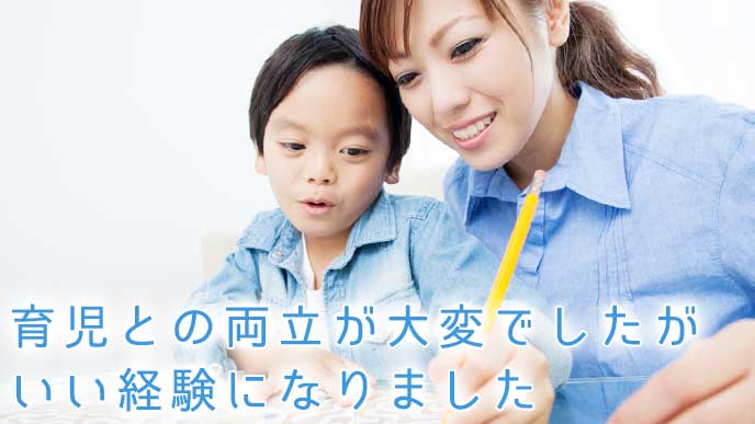 鉛筆を持つ子供を笑顔で見守る母親