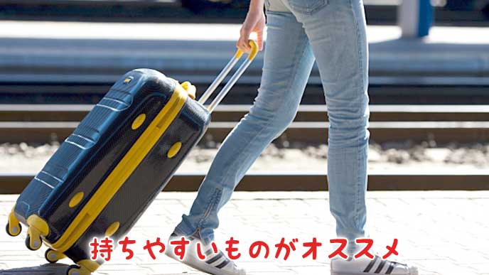 キャリーバッグを持って旅行をする女性