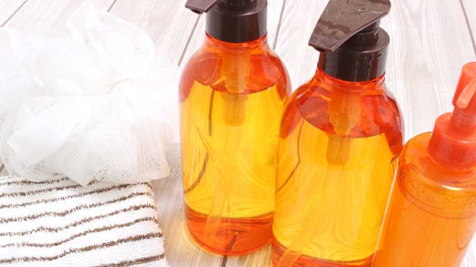 タオルとボトルに入ったシャンプーとリンス