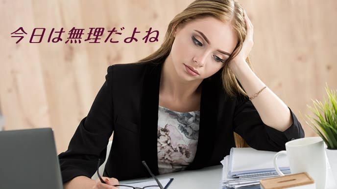 職場のデスクで考える女性