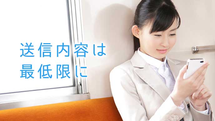 電車の中でLINEを送信する会社員の女性