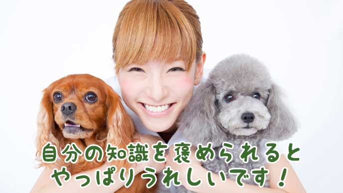 微笑みながら両脇で子犬を抱く獣医師の女性