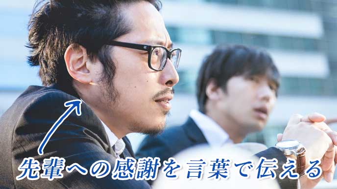 街の中、上を見て語り合う営業マンと先輩