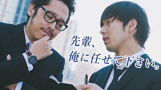 街中で先輩と仕事の打ち合わせをしている営業マン
