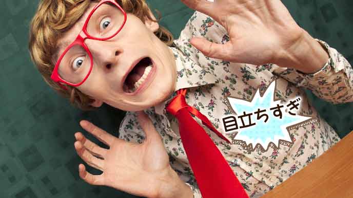 赤いネクタイと眼鏡で、派手な柄のシャツを着た男性