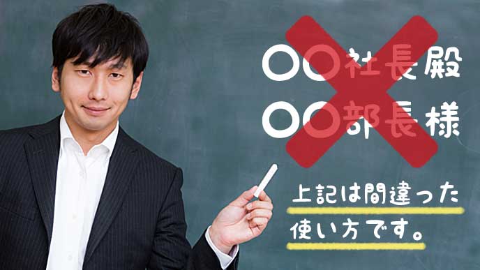 黒板に書いてある役職と敬称の使い方を説明する教師