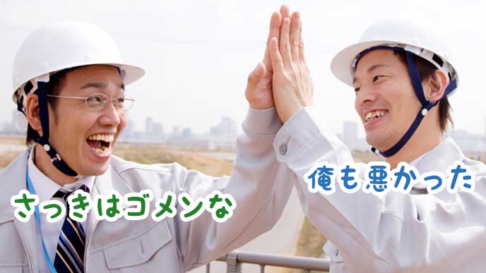 工事現場で仲直りのハイタッチをする作業員達