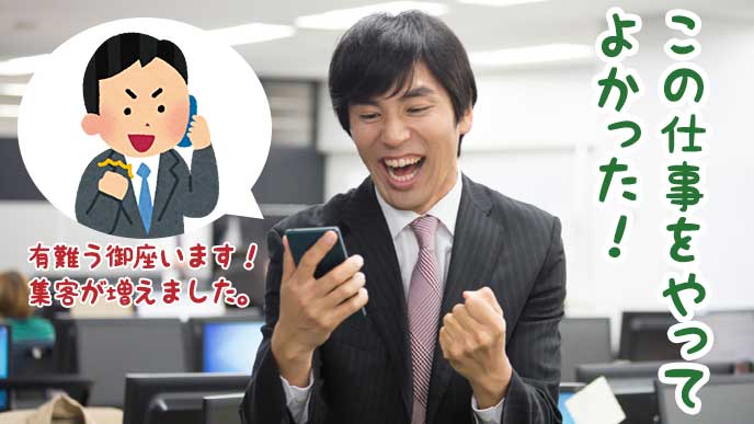 クライアントからお礼の電話を受け取りガッツポーズを取るビジネスマン