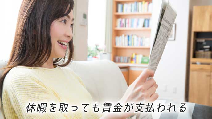 ソファに座り新聞を読んでいる女性