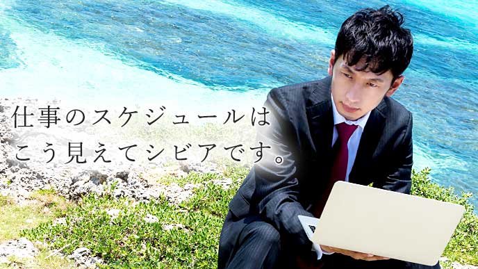 険しい表情でノートパソコンを使って仕事をしている男性